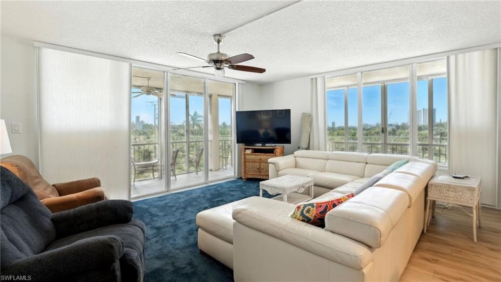 Living room with floor to ceiling windows and a textured ceiling - Virtually Edited Image