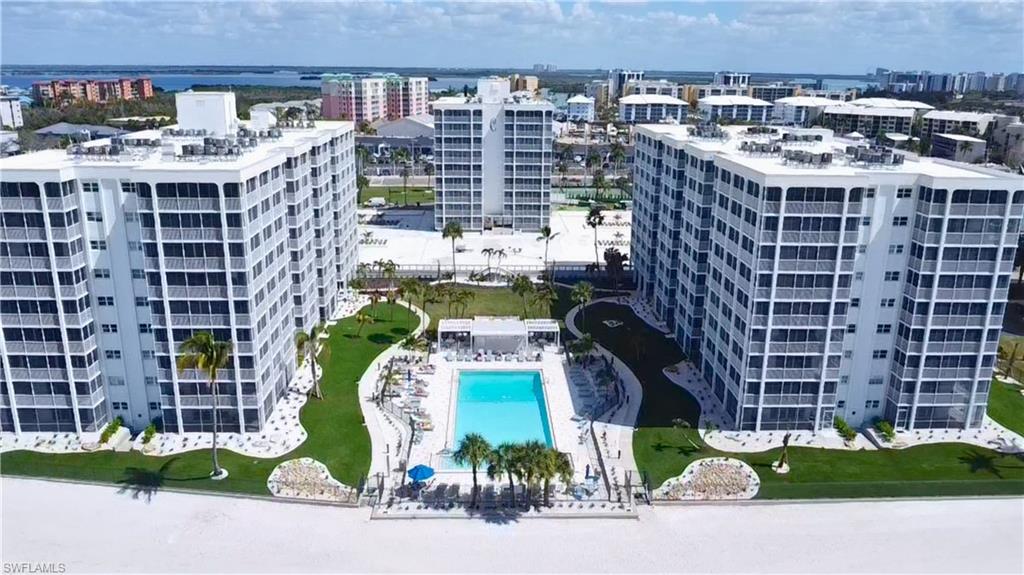 View of community pool area featuring a pool & condominium buildings, 7146 Estero Blvd-left, 7150 Estero Blvd-right, center building straight back 7148 Estero Blvd- Virtually Edited Image