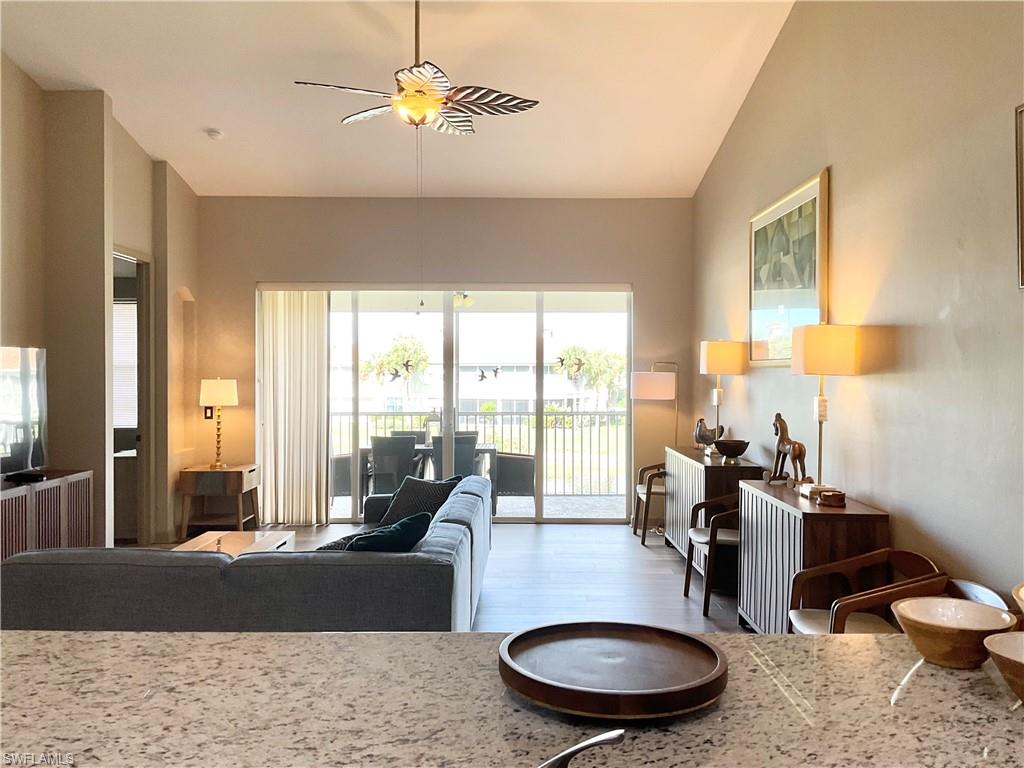 Living Room and Dining Area from kitchen with vaulted ceiling, vinyl wood-style flooring, and ceiling fan