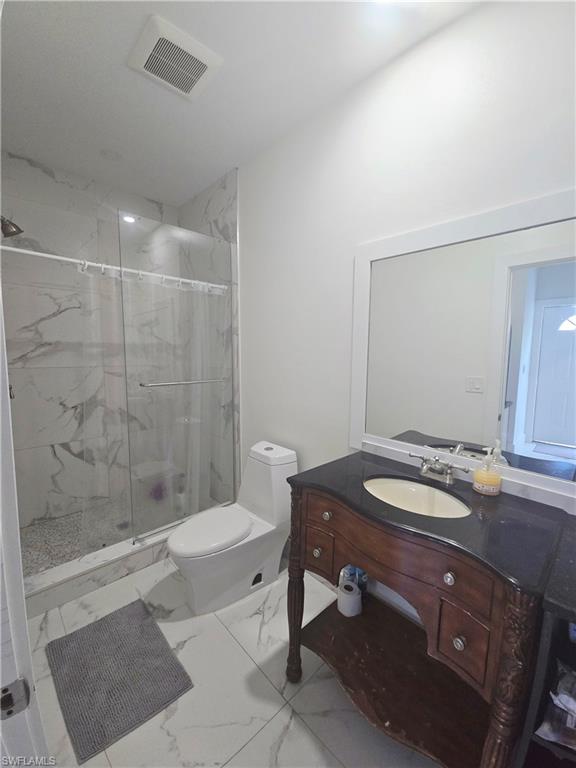 Mother-in-law Bathroom with vanity, a marble finish shower, and marble finish flooring