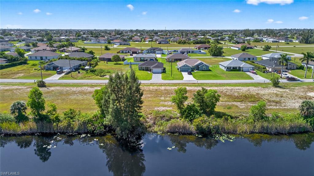 Aerial view of residential area featuring a nearby body of water
