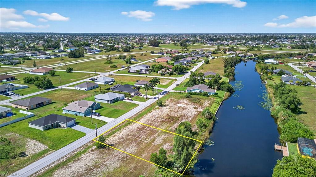 Aerial view of residential area featuring a nearby body of water and property boundaries highlighted