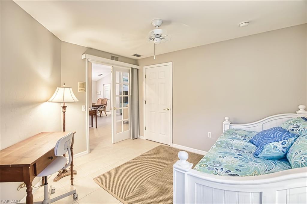 Bedroom featuring tile patterned flooring, ceiling fan, and french doors