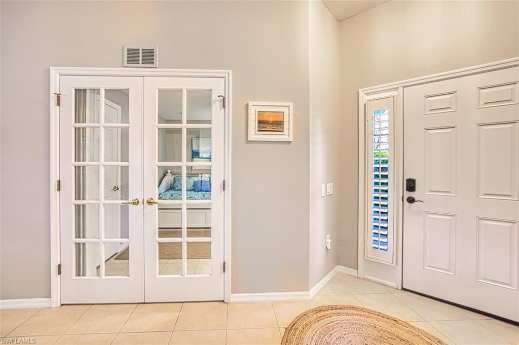 Foyer featuring french doors and light tile patterned flooring