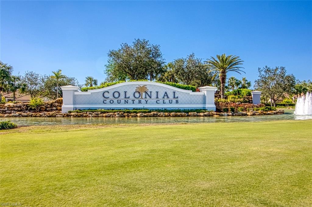 Community / neighborhood sign featuring a yard and a water view