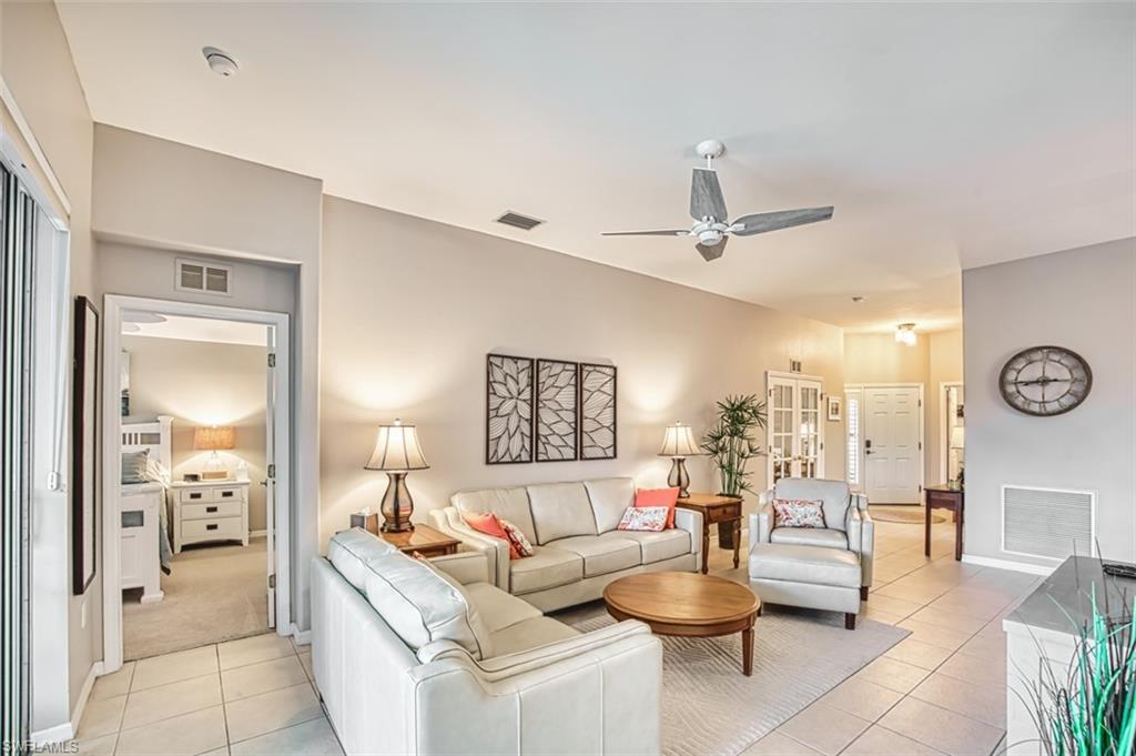 Living room featuring light tile patterned flooring and ceiling fan