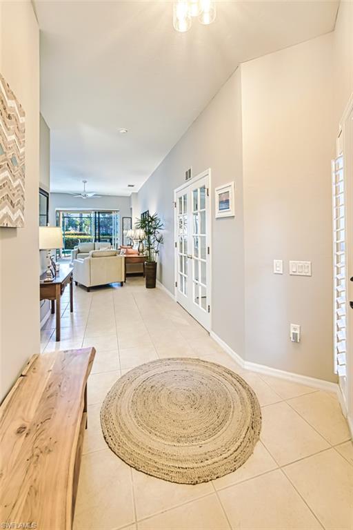 Hall with light tile patterned flooring and french doors