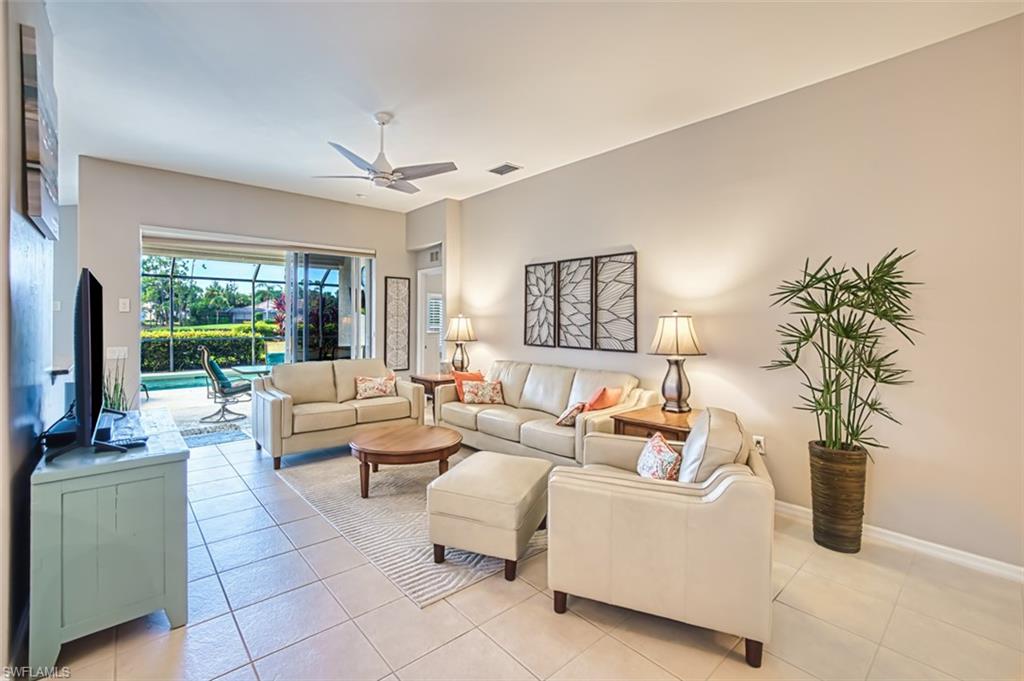Living area with a ceiling fan and light tile patterned flooring