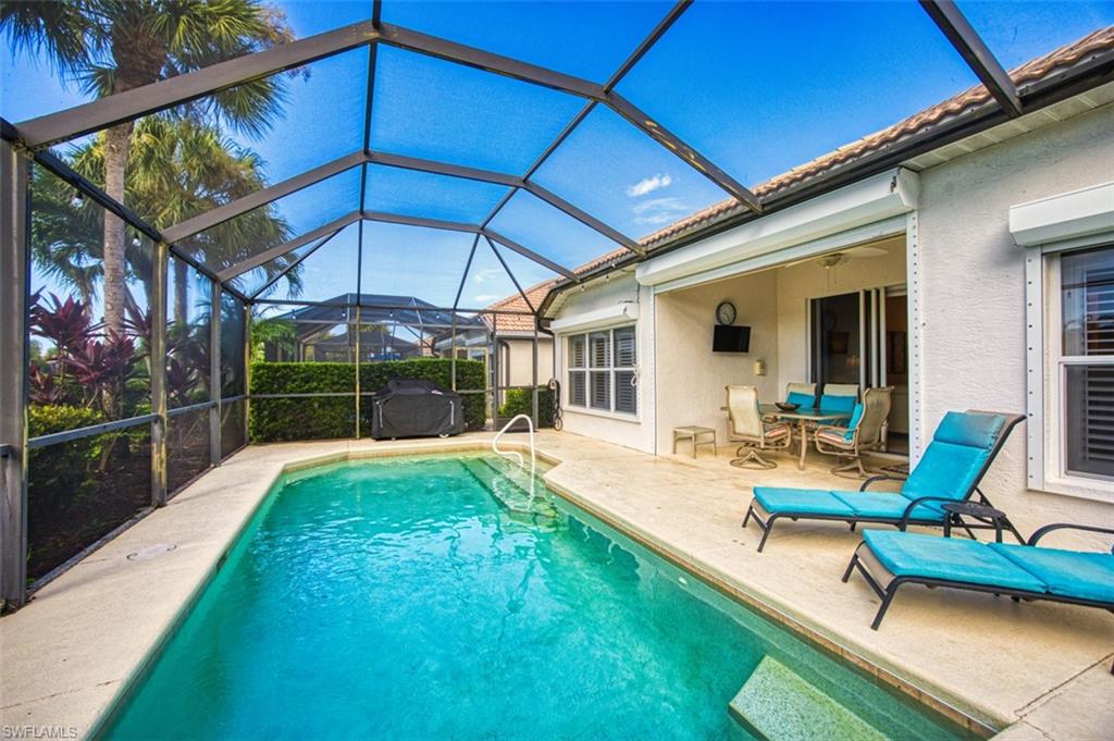 Swimming pool with glass enclosure, a sunroom, and a patio area