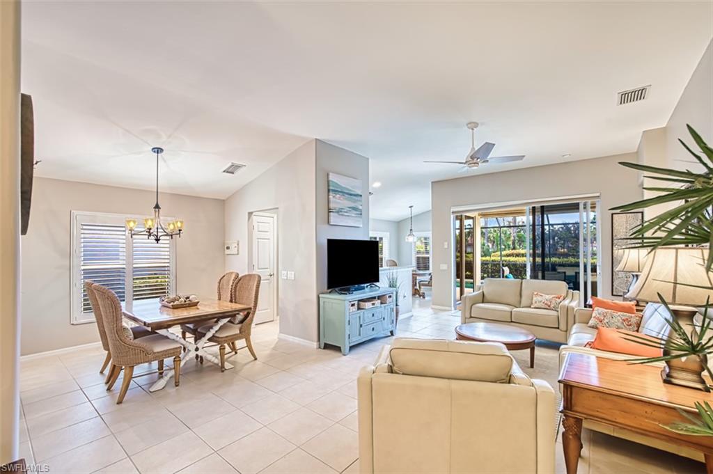 Living room with light tile patterned floors, a chandelier, vaulted ceiling, and recessed lighting