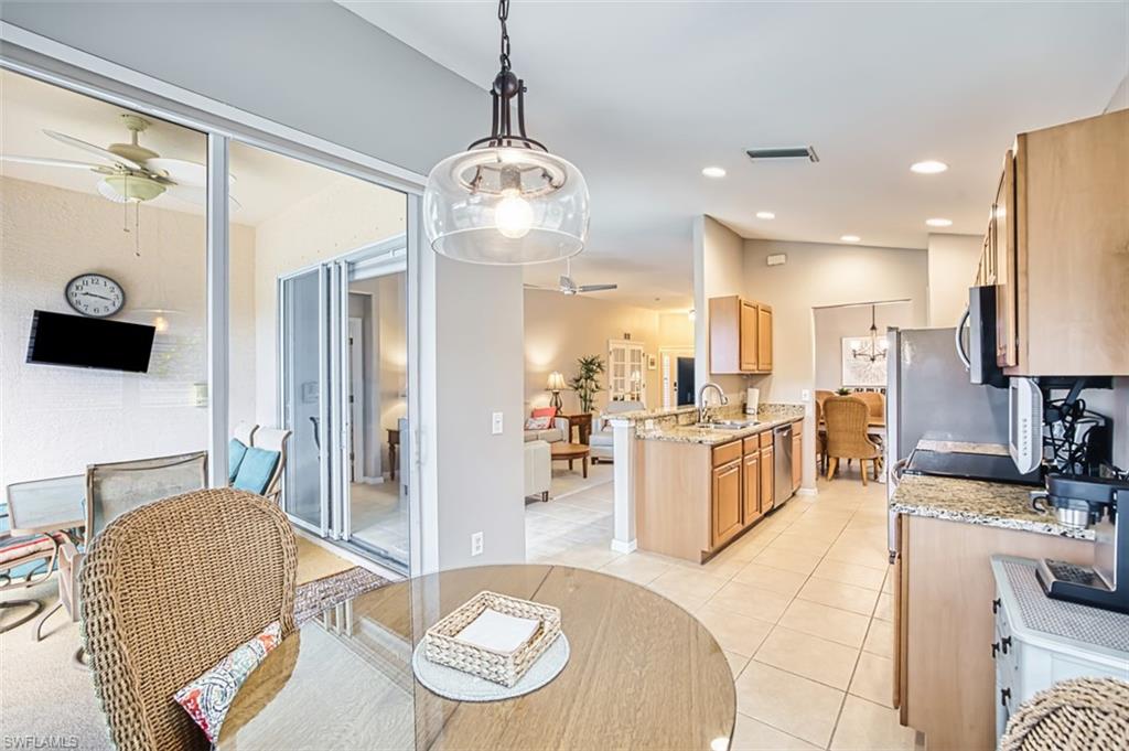 Kitchen with decorative light fixtures, light stone counters, light tile patterned floors, open floor plan, and recessed lighting