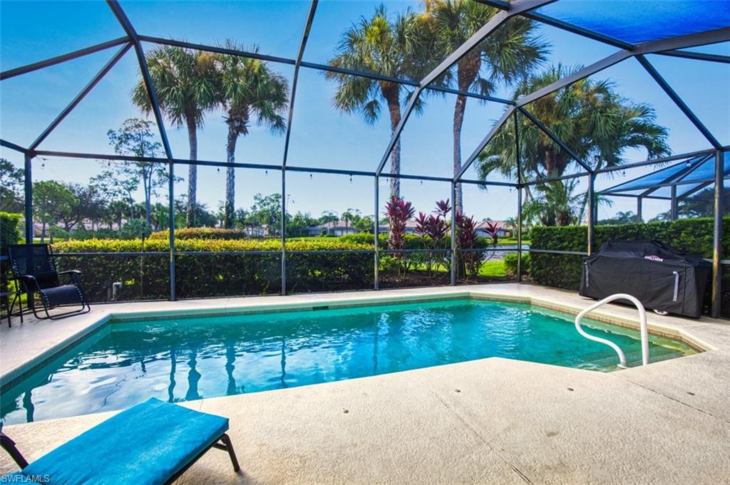Swimming pool featuring a sunroom, a patio, and glass enclosure