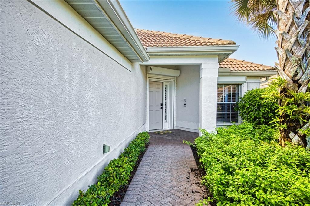 View of exterior entry with stucco siding and a tile roof