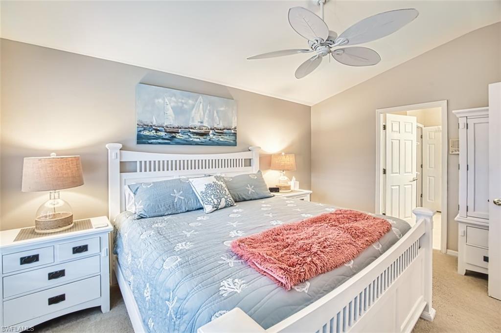 Bedroom with light colored carpet, lofted ceiling, and a ceiling fan