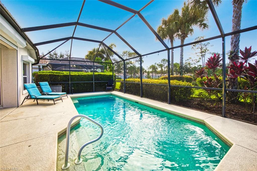 Swimming pool featuring a sunroom, a patio area, and glass enclosure