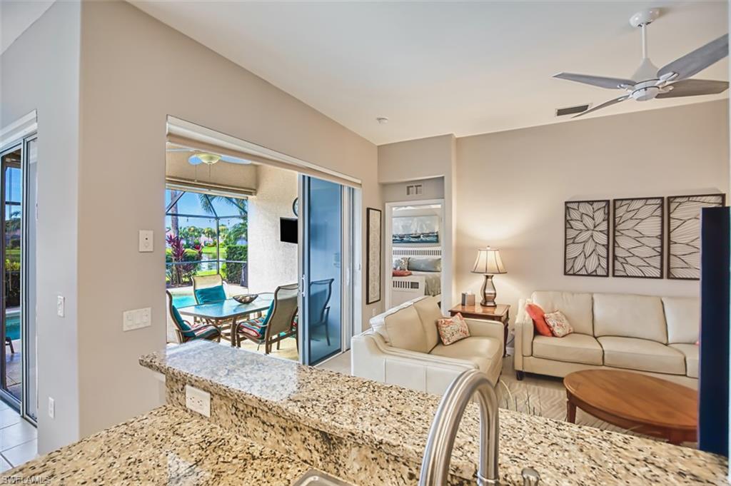 Living room featuring a ceiling fan, a sunroom, and light tile patterned floors