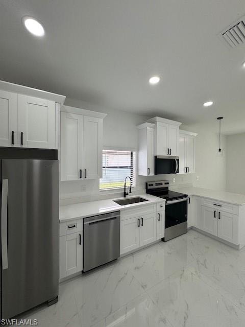 Kitchen with light marble finish flooring, refrigerator, stainless steel range, hanging light fixtures, and white cabinets