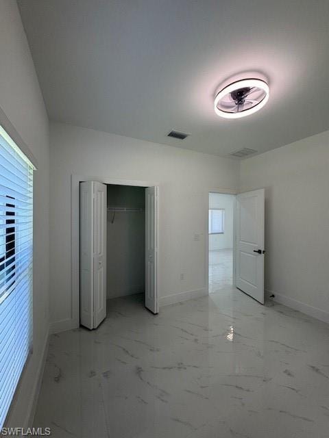 2-Unfurnished bedroom featuring light marble finish flooring and a closet