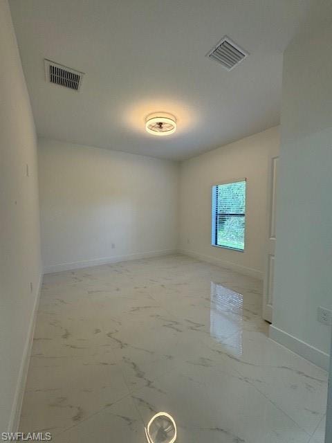 Unfurnished room with baseboards and light marble finish floors