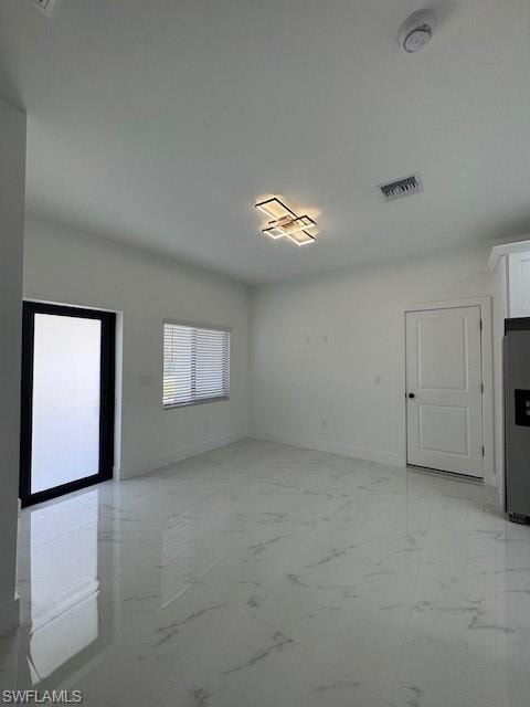 Unfurnished living room featuring light marble finish floors