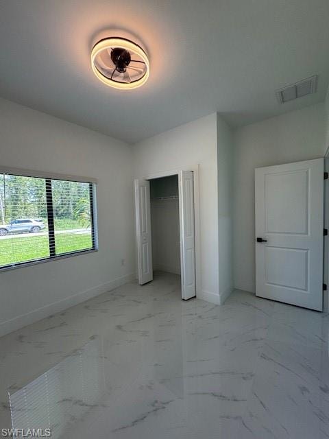 1-Unfurnished bedroom featuring light marble finish floors and a closet