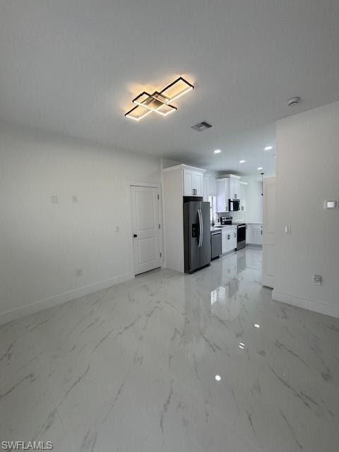 Unfurnished living room featuring light marble finish flooring and recessed lighting
