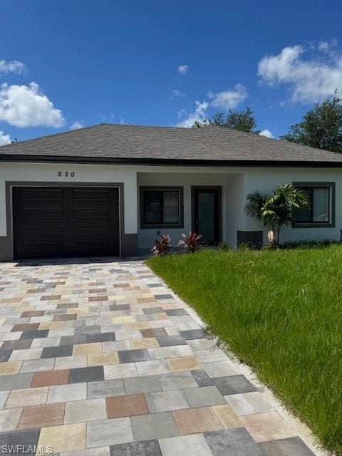 Ranch-style house with an attached garage, decorative driveway, stucco siding, and a shingled roof