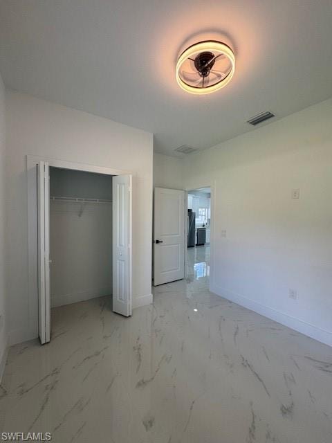 1-Unfurnished bedroom featuring light marble finish floors and a closet