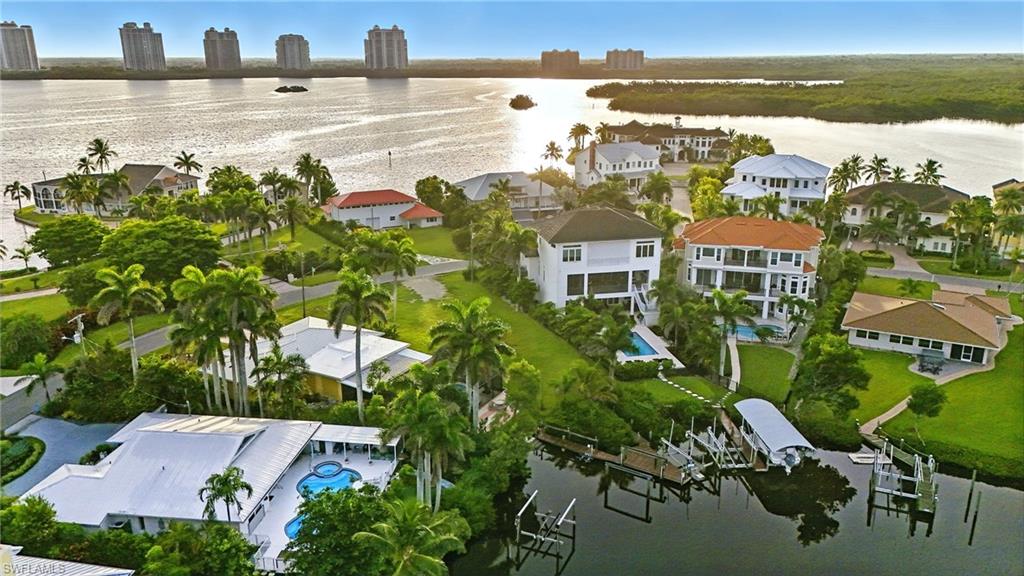 Aerial view of residential area featuring a large body of water and a pool