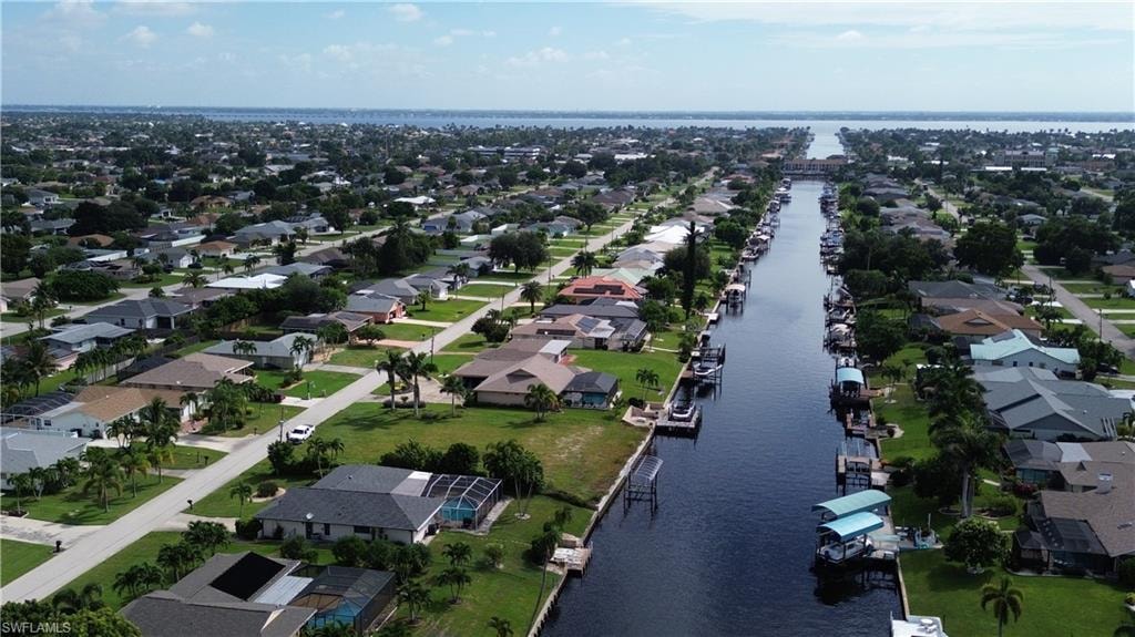 Aerial view of property and surrounding area with a nearby body of water and nearby suburban area