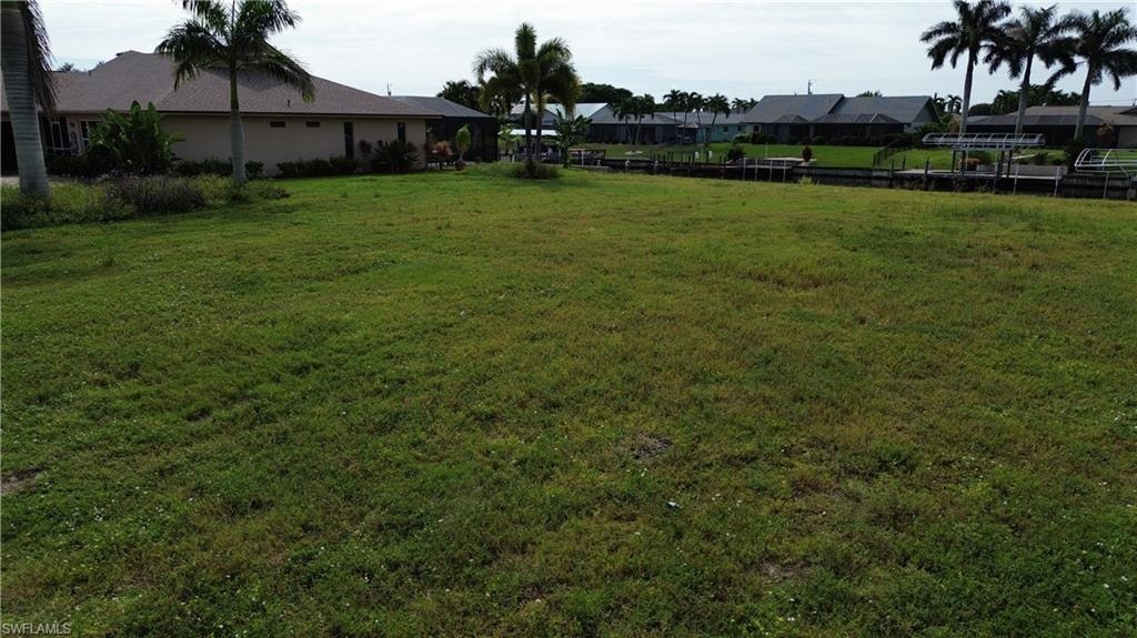 View of green lawn with a residential view