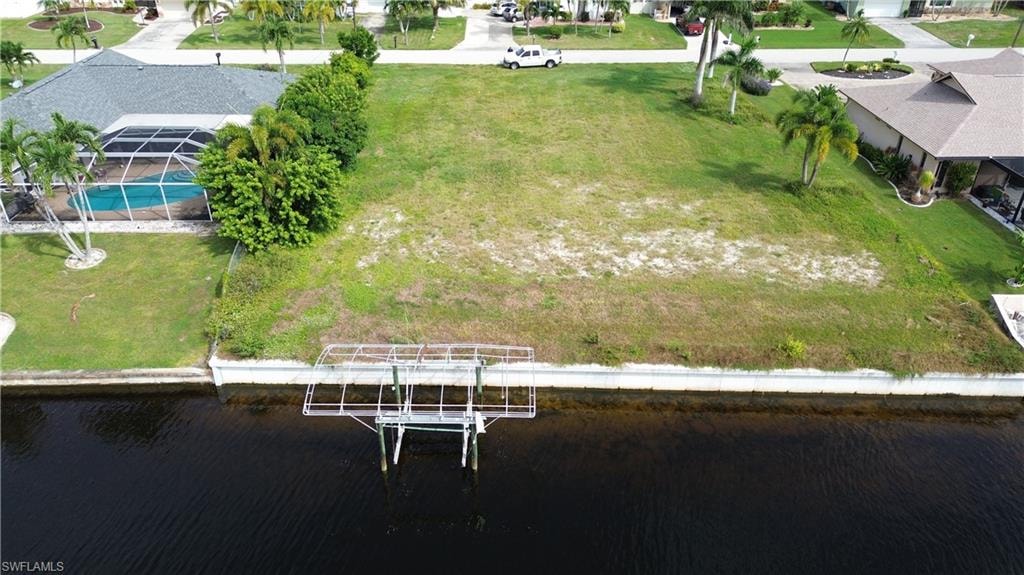 Aerial view of residential area featuring a nearby body of water and a pool