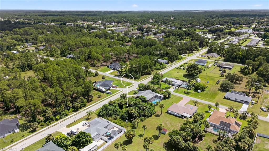 Aerial view of property and surrounding area with nearby suburban area