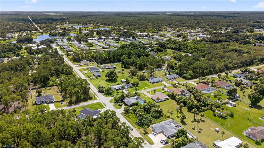 Aerial view of property and surrounding area featuring nearby suburban area and a nearby body of water