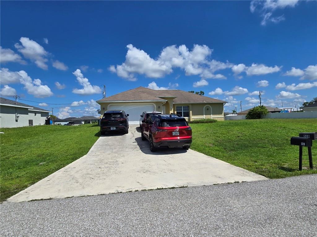 Ranch-style house featuring a front lawn, concrete driveway, an attached garage, and stucco siding