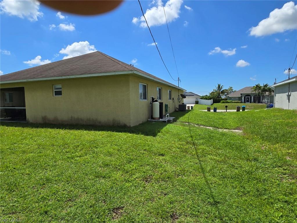 View of side of property featuring stucco siding and a lawn