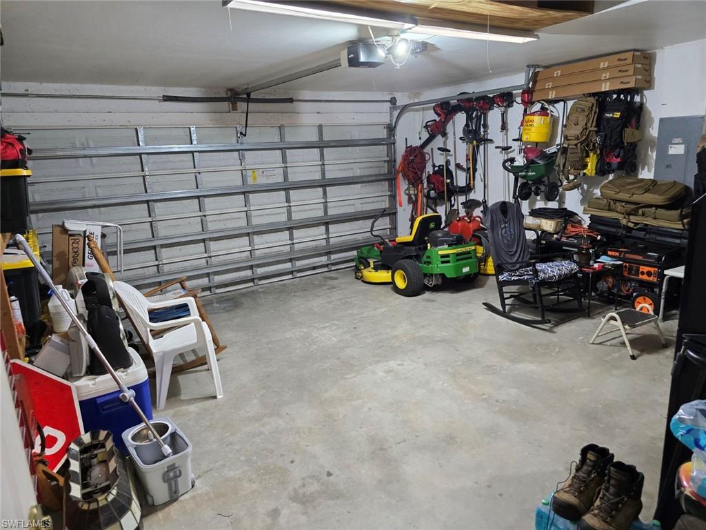 Garage featuring electric panel and a garage door opener