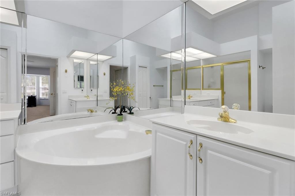 Primary bath featuring a large shower, soaking tub, two vanities and a linen closet