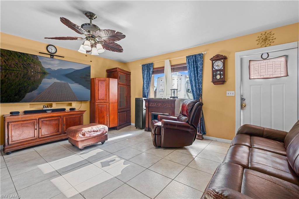 Living room featuring light tile patterned floors and ceiling fan