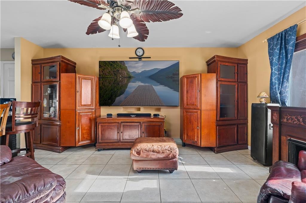 Living area featuring light tile patterned flooring and a ceiling fan