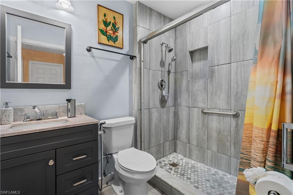 Bathroom featuring vanity, a stall shower, and a textured wall