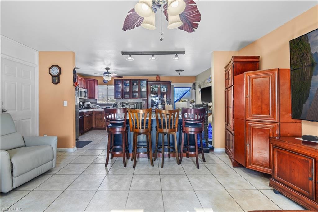 Dining room featuring light tile patterned flooring, rail lighting, and a ceiling fan