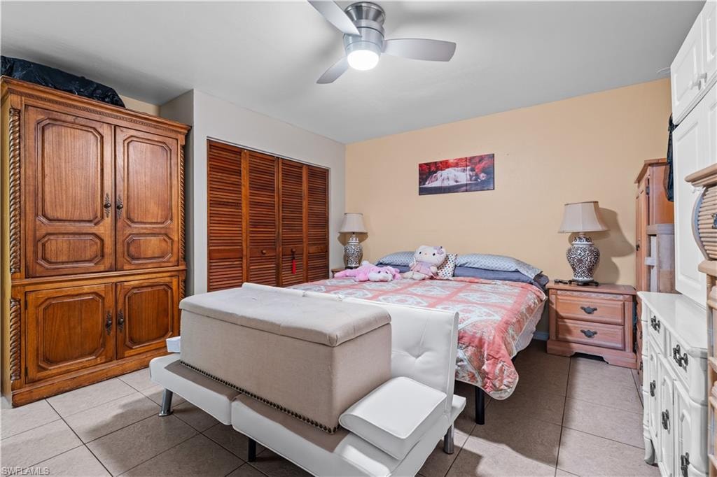 Bedroom featuring light tile patterned flooring, a ceiling fan, and a closet
