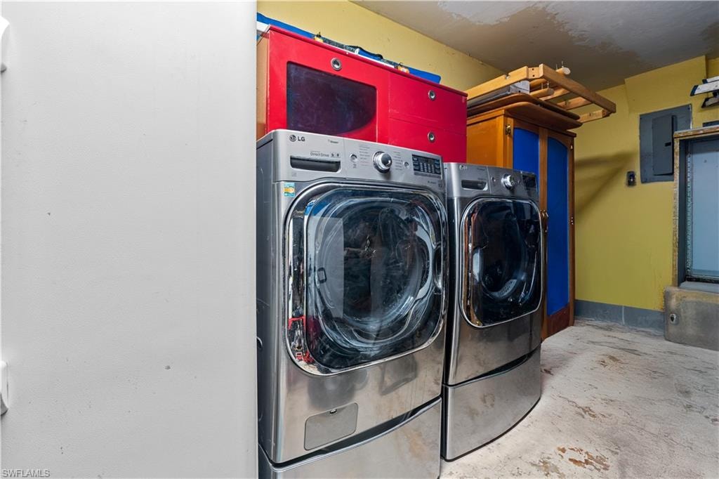 Washroom featuring washer and clothes dryer, electric panel, and cabinet space