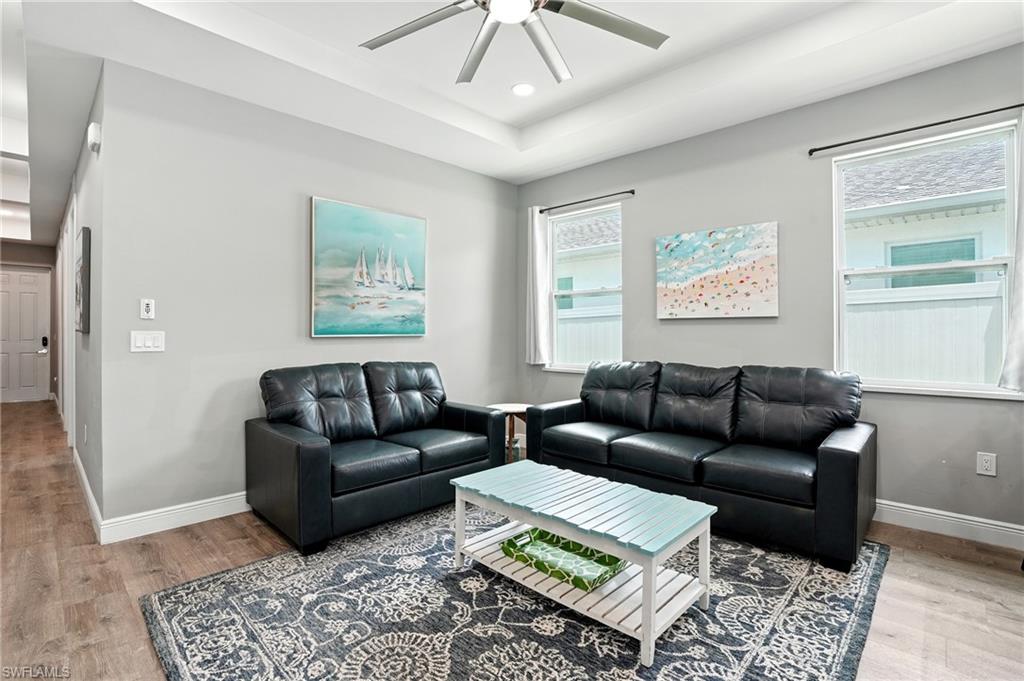 Living room featuring light wood-style flooring, ceiling fan, and recessed lighting