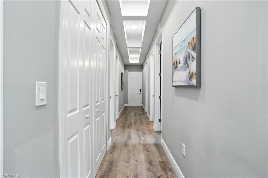Hallway with light wood-style flooring and recessed lighting