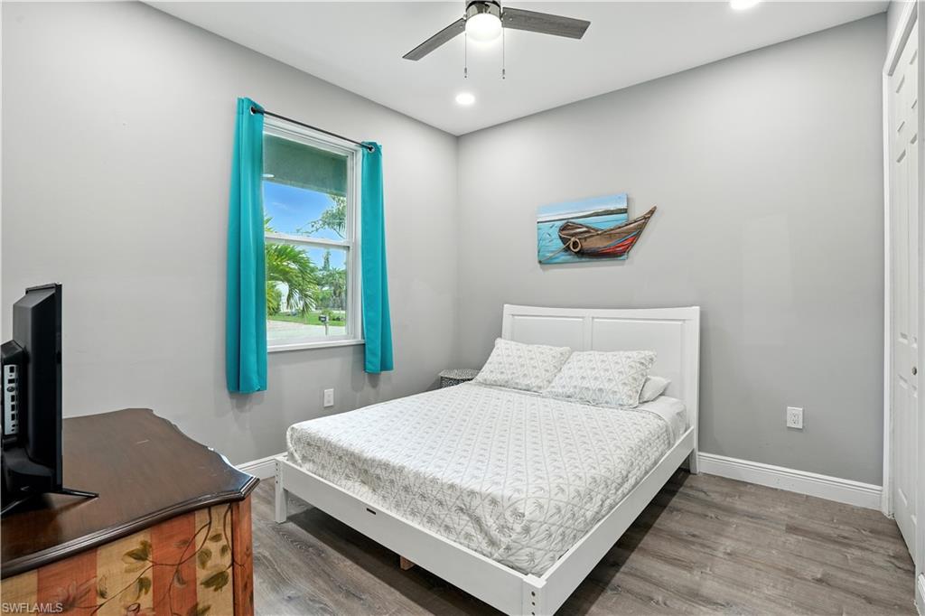 Bedroom with wood finished floors, ceiling fan, a closet, and recessed lighting