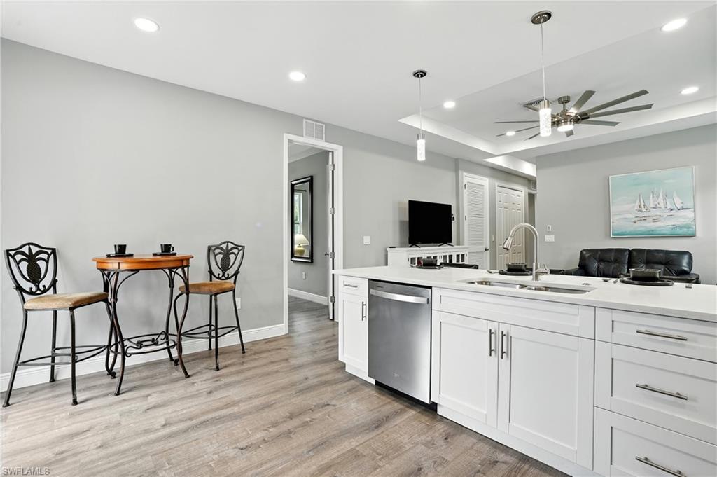 Kitchen featuring pendant lighting, white cabinetry, dishwasher, light wood-type flooring, and recessed lighting