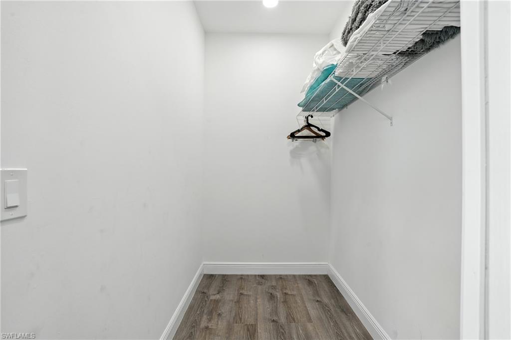 Walk in closet featuring dark wood-type flooring