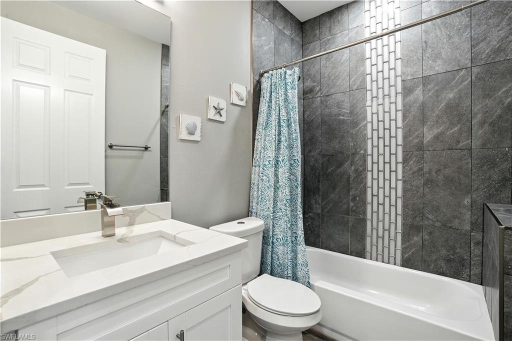 Full bath with shower / tub combo with curtain and vanity